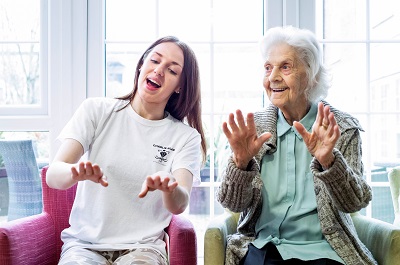 Charlie and resident Joan Hall go through a hand pattern